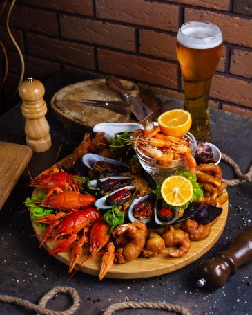seafood-plate-with-shrimps-mussels-lobsters-served-with-lemon-and-glass-of-beer-min
